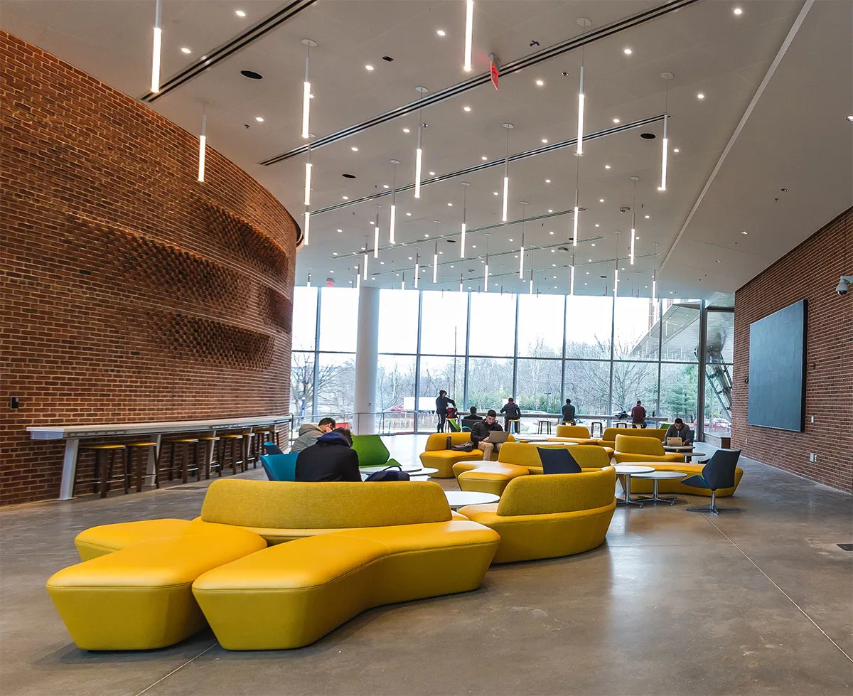 Modern interior space in a building. Students on couches