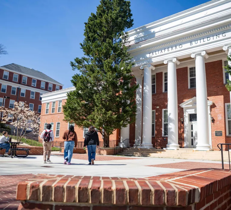 Students walking next to a columned building